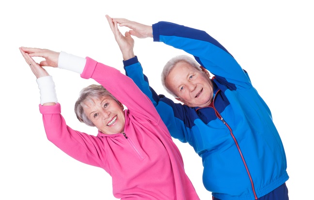A fit, older couple stretching in active wear.